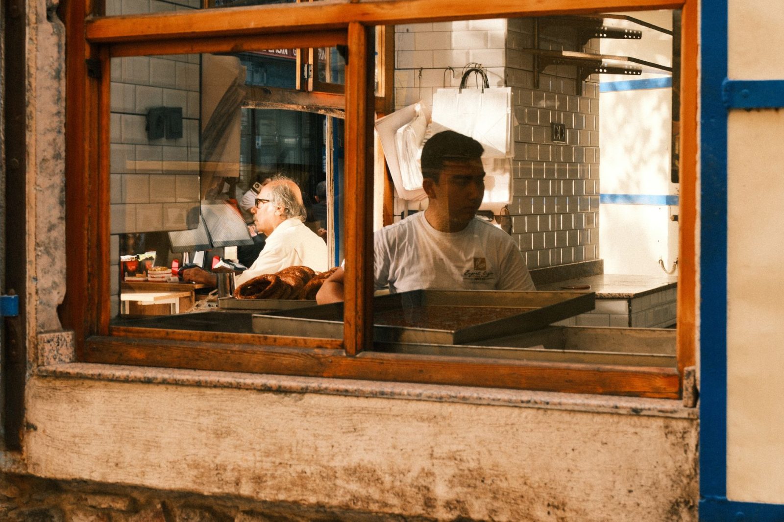 View through a bakery window of two staff members at work