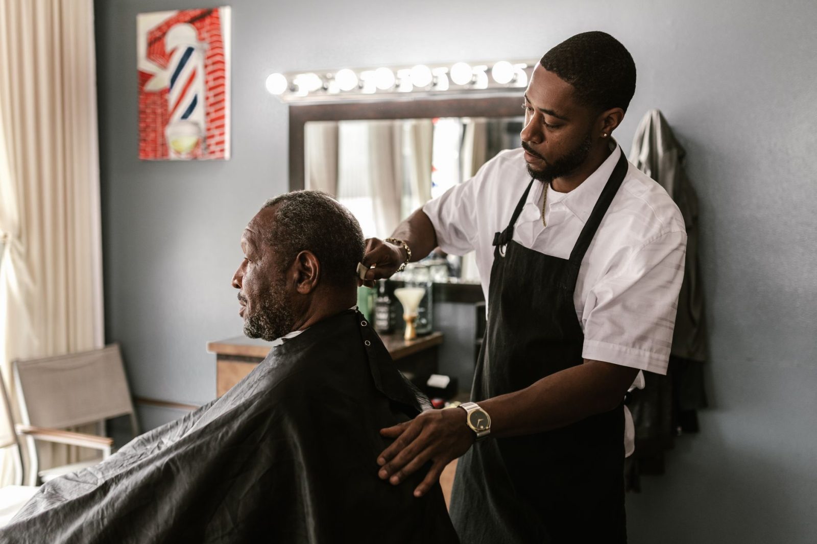 A barber cutting a customer’s hair in the shop