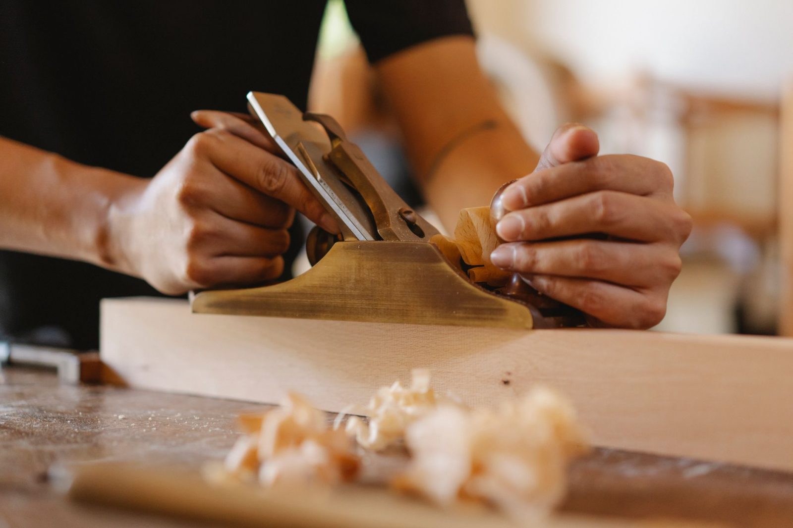A carpenter cutting wood in a dusty workshop